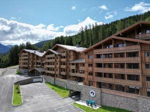 an apartment building in the mountains with a parking lot at TERRESENS - Le Snoroc in Aime La Plagne
