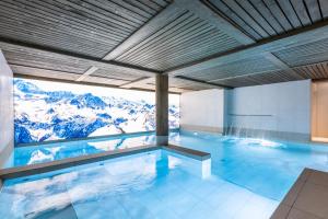 a swimming pool with a view of the mountains at TERRESENS - Le Snoroc in Aime-La Plagne