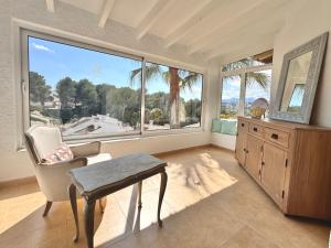 a living room with a chair and a large window at Casa Milana in Moraira