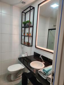 a bathroom with a sink and a mirror and a toilet at Studio West Fit in Mossoró