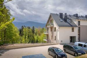 two cars parked in a parking lot in front of a house at Daj Sobie Spokój - WIDOK 800mnpm OGRÓDEK in Szklarska Poręba
