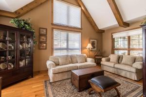 een woonkamer met twee banken en een tafel bij Tremblant Prestige - Equinoxe 140-1 in Mont-Tremblant