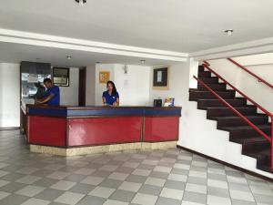 two people standing at a counter in a restaurant at Hotel Subaé in Feira de Santana