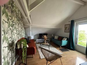 a living room with a couch and a chair at Une ambiance cosy avec jardin privatif in Nassandres