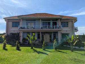 a house with a large yard with palm trees at Eden Villas in Entebbe