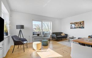 a living room with chairs and a table at 2 Bedroom Amazing Home In Ringkøbing in Ringkøbing