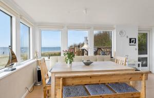 Øster AsselsにあるNice Home In Øster Asselsのテーブルと窓のあるダイニングルーム