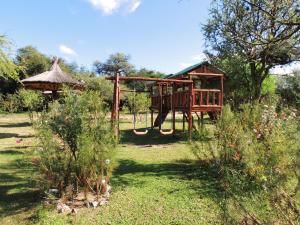 a playground in a garden with a swing at Cabañas Mandala in San Marcos Sierras