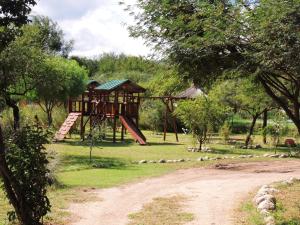 un patio de recreo en un parque con un árbol en Cabañas Mandala, en San Marcos Sierras