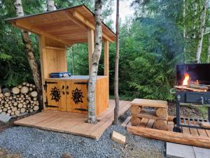 a wooden gazebo with a fireplace and a stove at Glamping Štôla Brezovy vanok in Vyšné Hágy