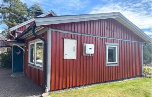a red shed with a white door and a window at 1 Bedroom Stunning Home In Mullsjö in Mullsjö