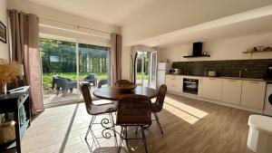 a kitchen and dining room with a table and chairs at Ilha Grande, maison de campagne in Ponthoile +11 photos