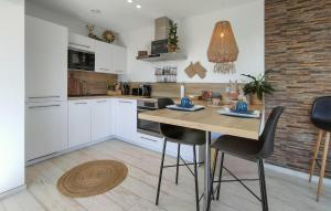 a kitchen with white cabinets and a wooden table with chairs at 1 Bedroom Lovely Apartment In Visé in Visé