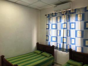 una camera con due letti in una stanza con una tenda di R P G Rest House a Nikawatawana