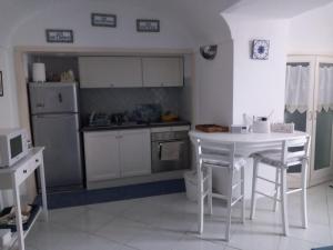 a kitchen with a white table and a white counter top at La lucciola in Capri
