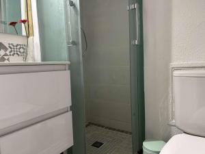 a bathroom with a toilet and a glass shower door at Appartement cosy, 2 pièces, proche plage et parking sécurisé - FR-1-229D-150 in Fleury