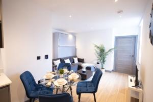 a living room with a table and chairs and a couch at New London 2 Bedroom, 2 Bathroom Flat in Finchley +14 photos