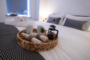 a basket of towels and a coffee maker on a bed at New London 2 Bedroom, 2 Bathroom Flat in Finchley