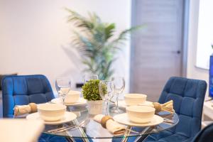 a dining table with chairs and a table with glasses at New London 2 Bedroom, 2 Bathroom Flat in Finchley
