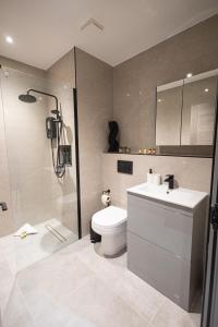 a bathroom with a toilet and a shower and a sink at New London 2 Bedroom, 2 Bathroom Flat in Finchley