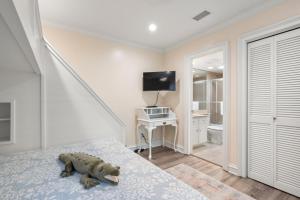 Un osito de peluche sentado en una cama en un dormitorio. en 4416 Windswept Villa by Akers Ellis Rentals, en Kiawah Island