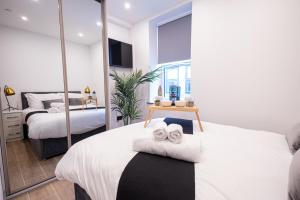 a bedroom with two beds and a mirror at Chic 2King BD Apt London with Ensuite & Pull Out Bed in Finchley +32 photos