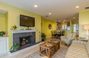 ein Wohnzimmer mit Kamin und Fernseher in der Unterkunft 4429 Windswept Villa by Akers Ellis Rentals in Kiawah Island