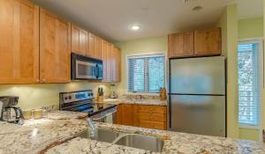 eine Küche mit Holzschränken und einem Edelstahlkühlschrank in der Unterkunft 4429 Windswept Villa by Akers Ellis Rentals in Kiawah Island