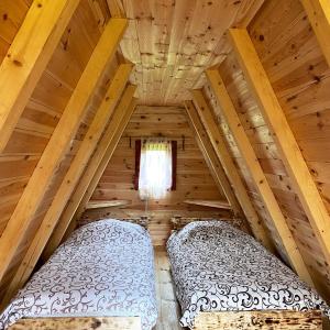 a bedroom in a log cabin with two beds at Eco kutak 3 in Mojkovac