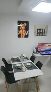 Una mesa blanca con sillas y una mesa con estufa. en Anna's cozy house, en Ángeles