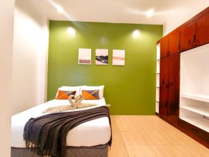 a bedroom with a green wall and a bed at Townhouse 4BR in La Guardia near IT Park Cebu City in Cebu City