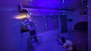 Un dormitorio con iluminación violeta y ositos de peluche dentro. en Anna's cozy house, en Ángeles 33 fotos más