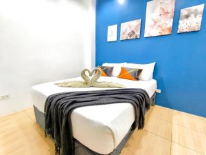 a bedroom with a bed with a blue wall at Townhouse 4BR in La Guardia near IT Park Cebu City in Cebu City