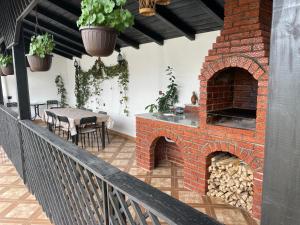 a patio with a brick oven with a table and chairs at Casa Ella Maldaresti in Măldăreşti