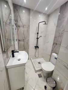 a white bathroom with a toilet and a sink at luxury Apartament TD one bedroom in Sofia +31 photos