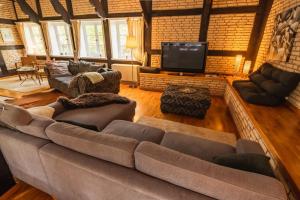 ein Wohnzimmer mit Couch und Flachbildfernseher in der Unterkunft Romantische, alte Wassermühle in Rieste