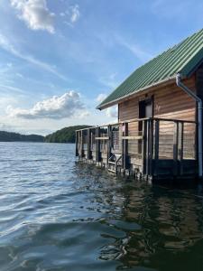 a house on a dock on a body of water at Chalets flottants lac de Saint Étienne Cantalès in Saint-Gérons