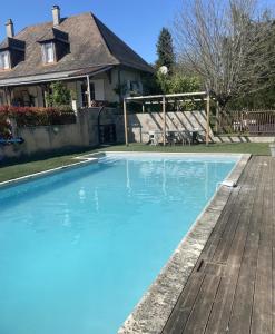 a swimming pool in front of a house at Les demoiselles de grignols in Grignols Dordogne