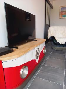 a tv on top of a red and white table at Country house, 8 people in Quemper-Guézennec +9 photos