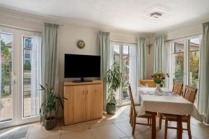 ブルンタールにあるFerienwohnung Alpencityのリビングルーム(テレビ、テーブル、椅子付)