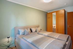 ブルンタールにあるFerienwohnung Alpencityの白いシーツと枕が備わったベッドのある寝室