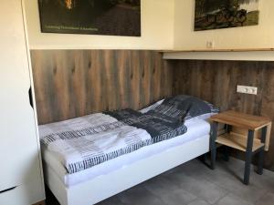 a bed in a room with a wooden wall at Fichtenhain - Lastering Ferienhäuser & Apartments in Wettringen