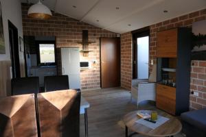 WettringenにあるHanna-Liese - Lastering Ferienhäuser & Apartmentsのレンガの壁のリビングルーム(テーブル付)