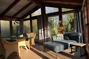 a screened in porch with a bed and a table at Marlies - Lastering Ferienhäuser & Apartments in Wettringen