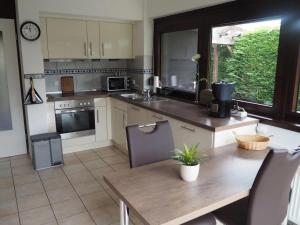 a kitchen with a wooden table and a counter top at Haselbusch - Lastering Ferienhäuser & Apartments in Wettringen