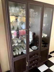 a wooden cabinet filled with plates and dishes at The Vatican Villa in Nuwara Eliya