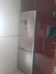 a white refrigerator in a kitchen next to a red cabinet at Chambre d'hôte jardins de Hamria in Meknès