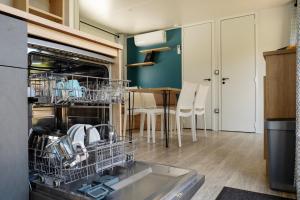 a dishwasher in a kitchen with a table at Mobilhome-Bali Premium by Camping Lampele-Ossiachersee-Klimaanlage-Radfahren-Wandern-Auszeit in Altossiach
