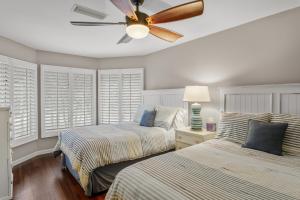 キアワ・アイランドにある4828 Turtle Cove Villa by Akers Ellis Rentalsのベッド2台と天井ファン付きの寝室