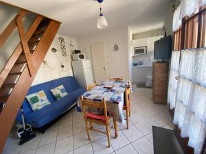 a living room with a table and a blue couch at Maison Normandie 19 in Fort-Mahon-Plage